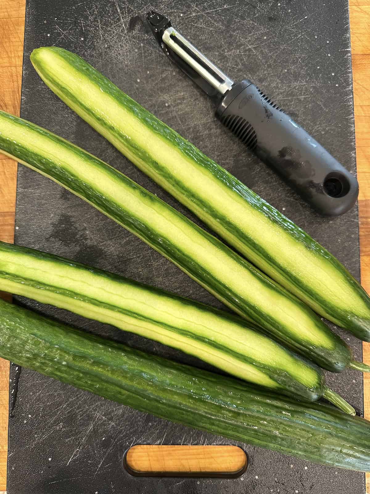 Cucumbers half peeled for refrigerator pickles.
