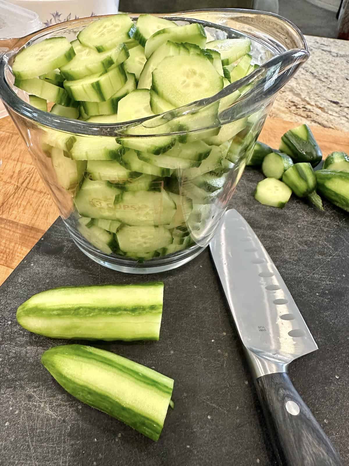 Sliced cucumbers in a measuring cup.