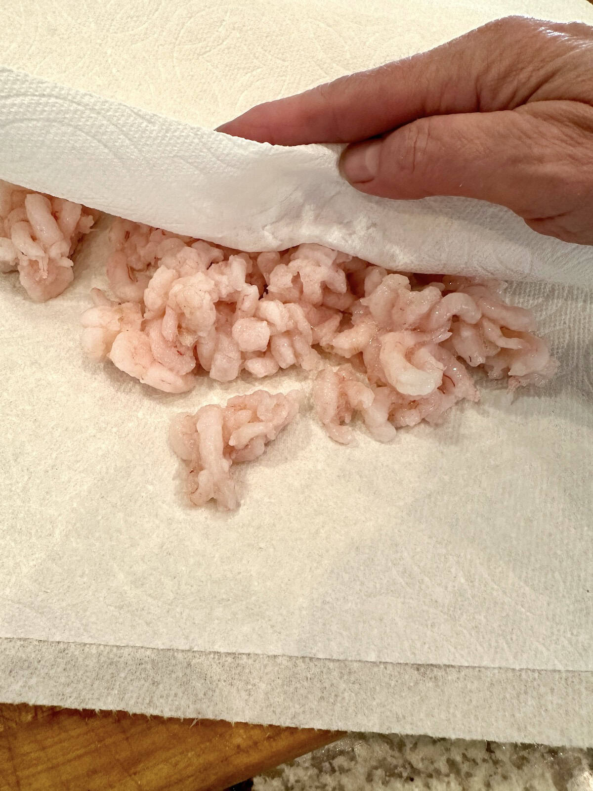 Shrimp for seafood dip between two paper towels.