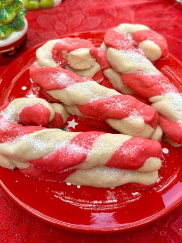 Christmas candy cane cookies stacked on a plate.