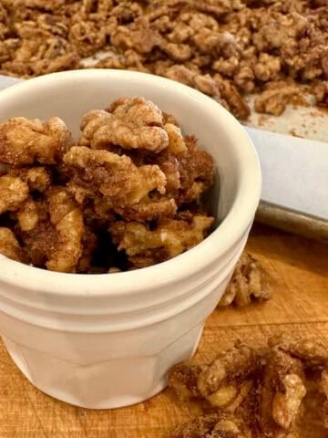 Close-up of spiced walnuts roasted with cinnamon and sugar in a jar.