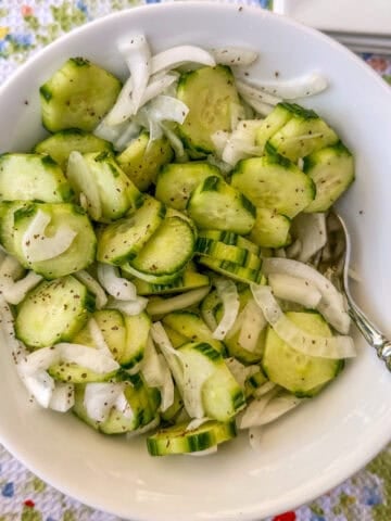A serving of quick pickled cucumbers in a bowl.