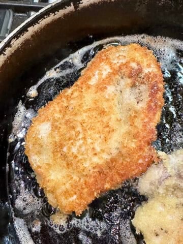 Chicken with crispy panko breading in a skillet.