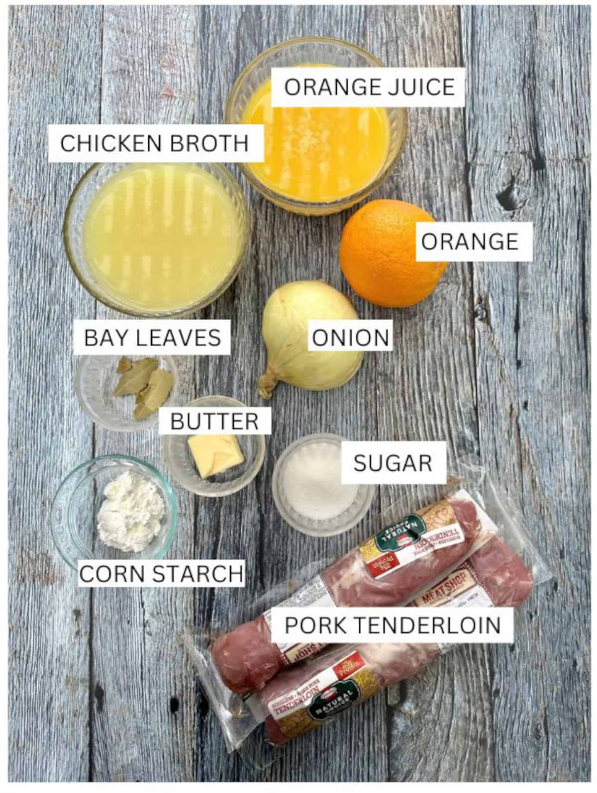 Orange pork tenderloin ingredients on a wooden table with labels.