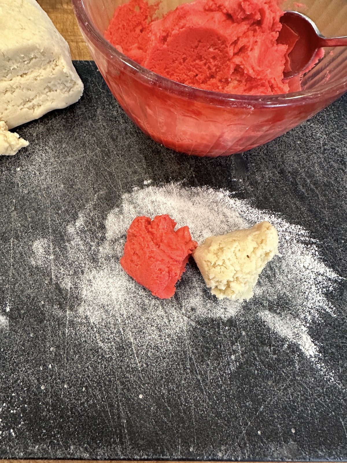 Two pieces of candy cane cookie dough on a cutting board.