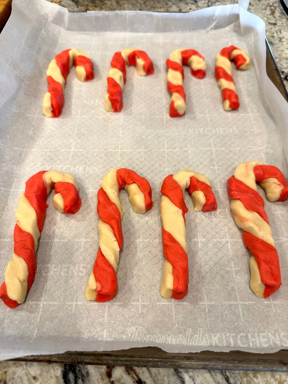 Unbaked candy cane cookies on a baking sheet.
