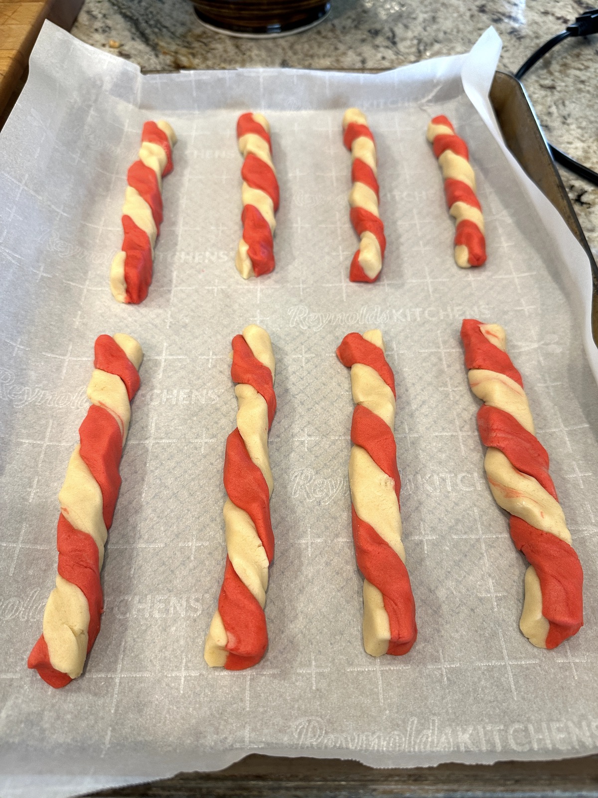 Candy cane cookies arranged on a baking sheet.