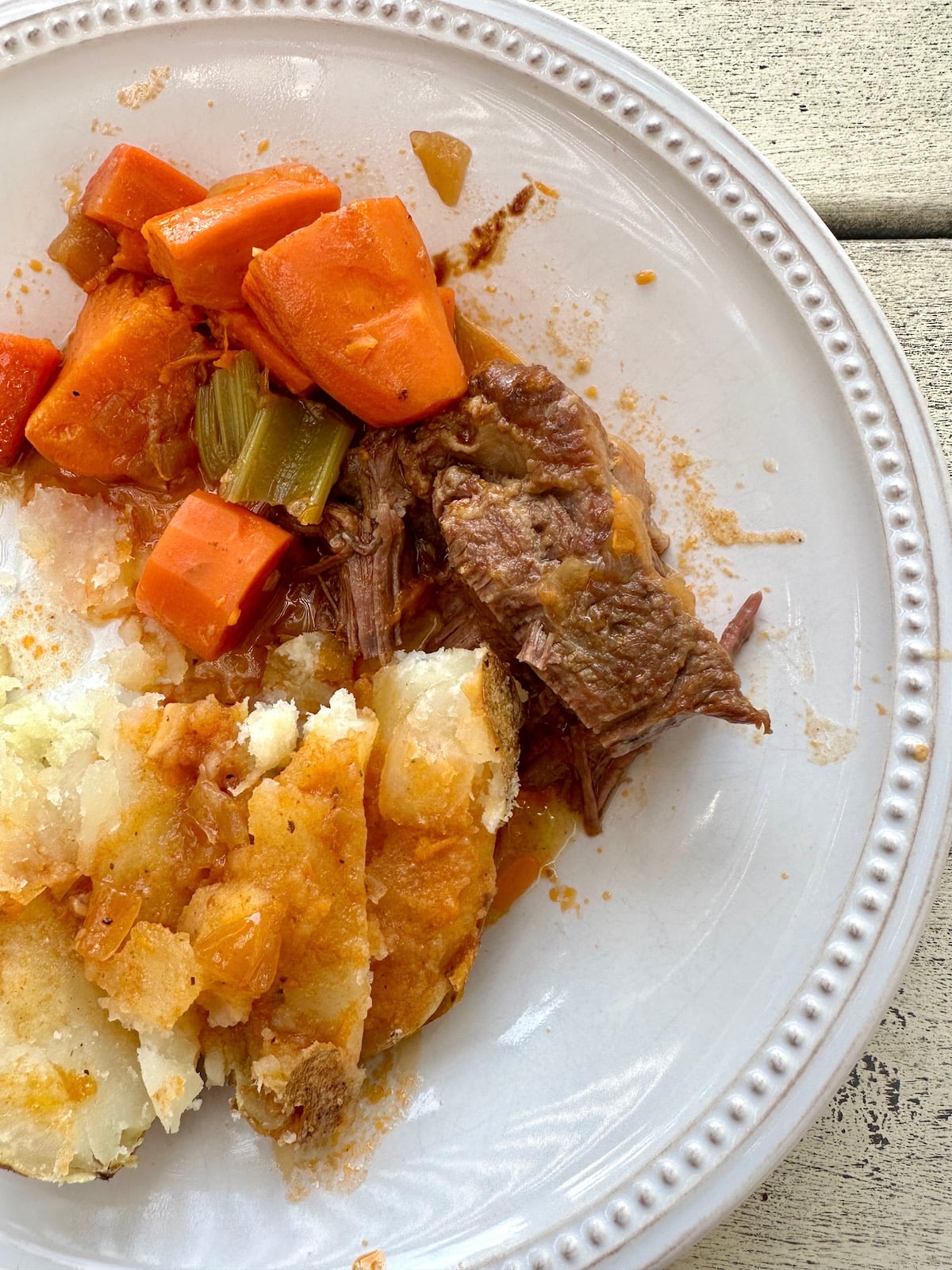 Dutch oven pot roast on a plate with vegetables.