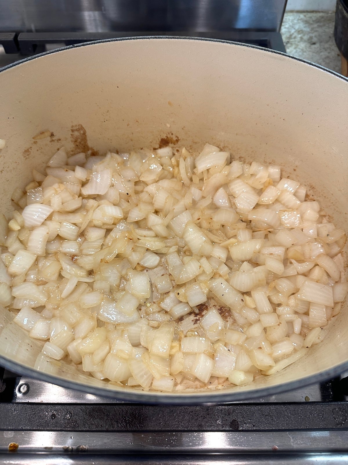 Diced onions and garlic in a Dutch oven on the stove.
