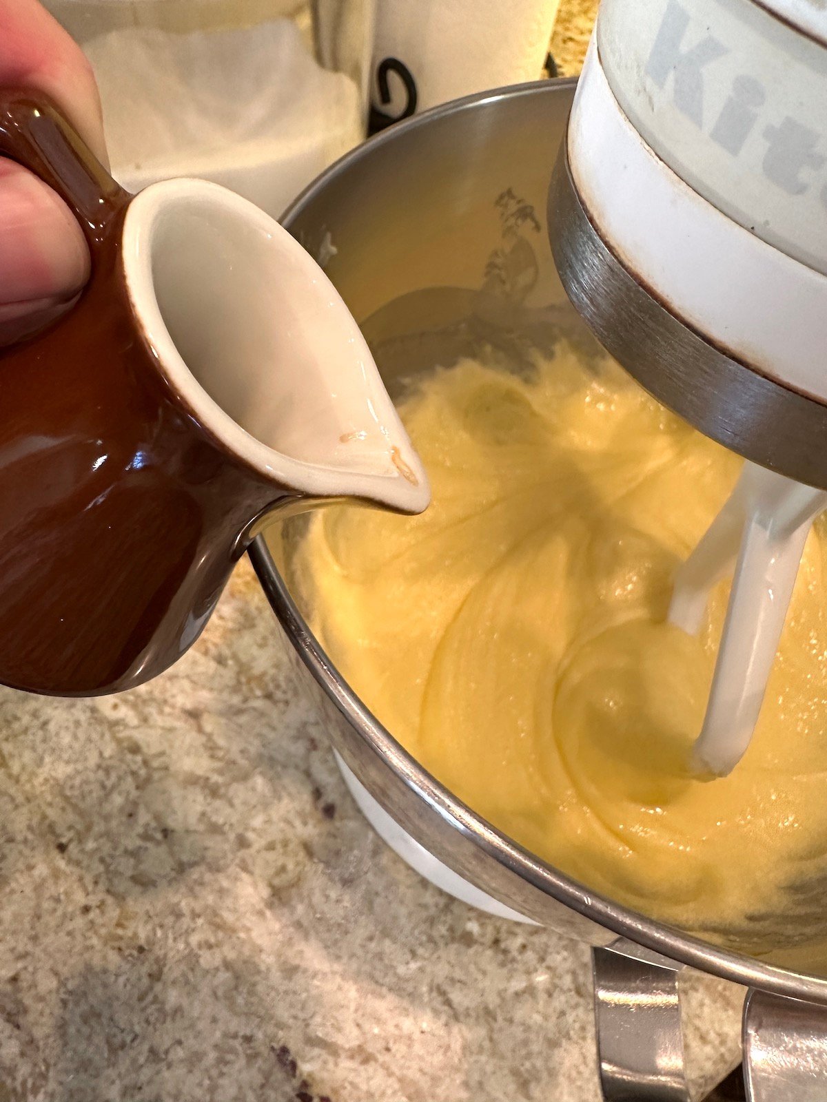 Vanilla extract added to a mixing bowl of zucchini chocolate cake ingredients.