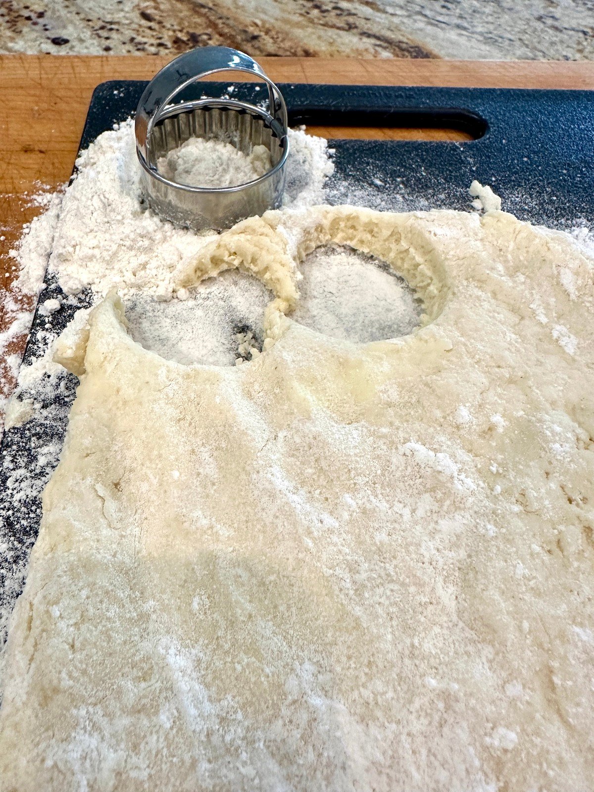 A cookie cutter with homemade biscuit dough.