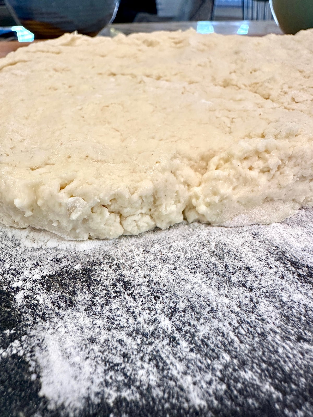 Homemade biscuit dough rolled out on a cutting board.
