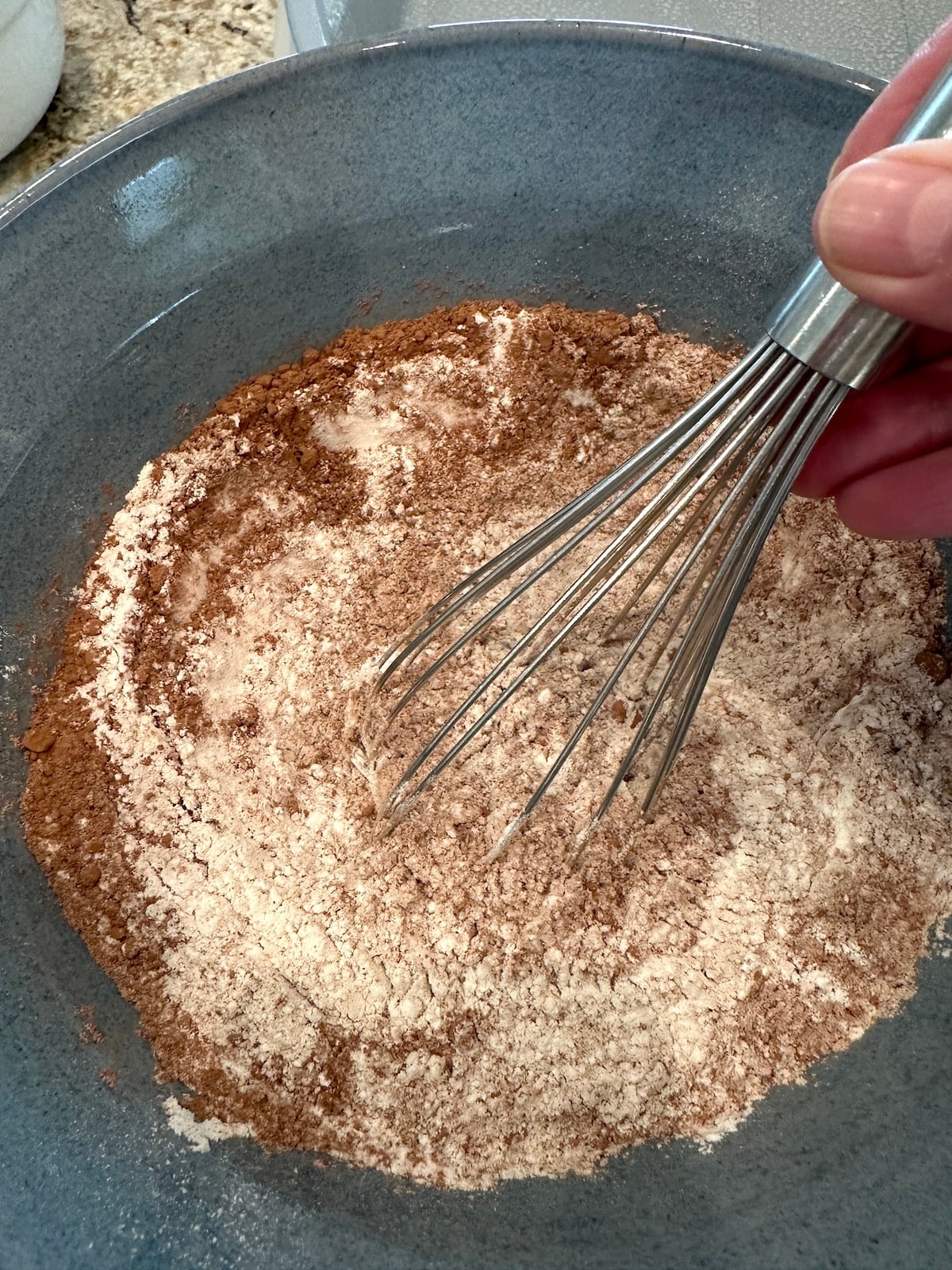 Dry ingredients for chocolate zucchini cake, whisked together in a bowl.