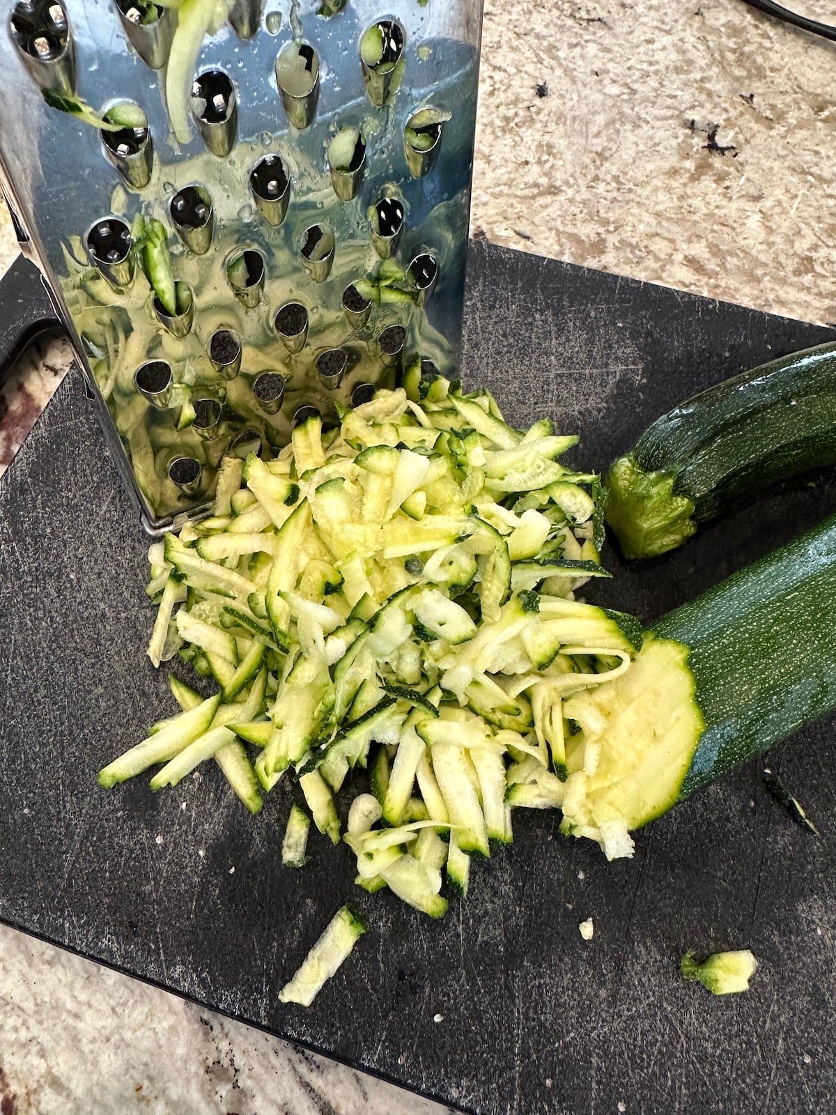 Grated zucchini on a cutting board.