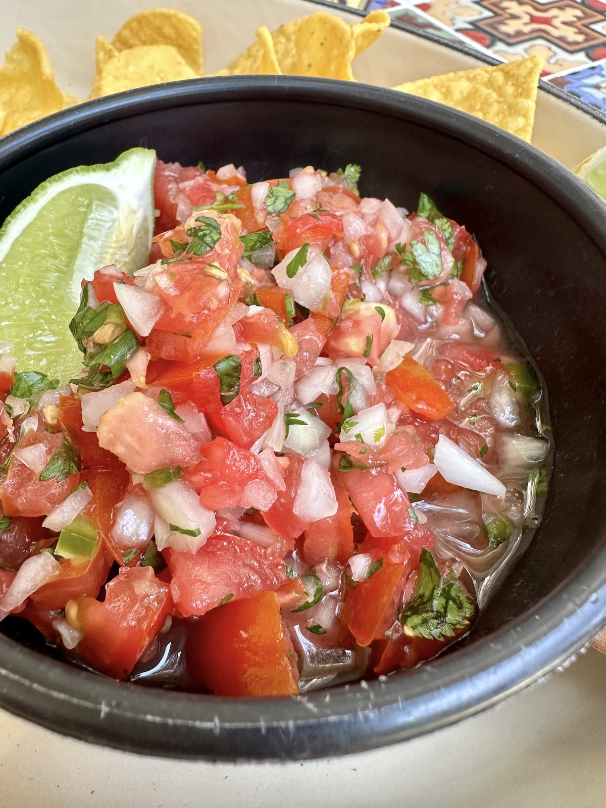 Homemade pico de gallo in a bowl with chips.