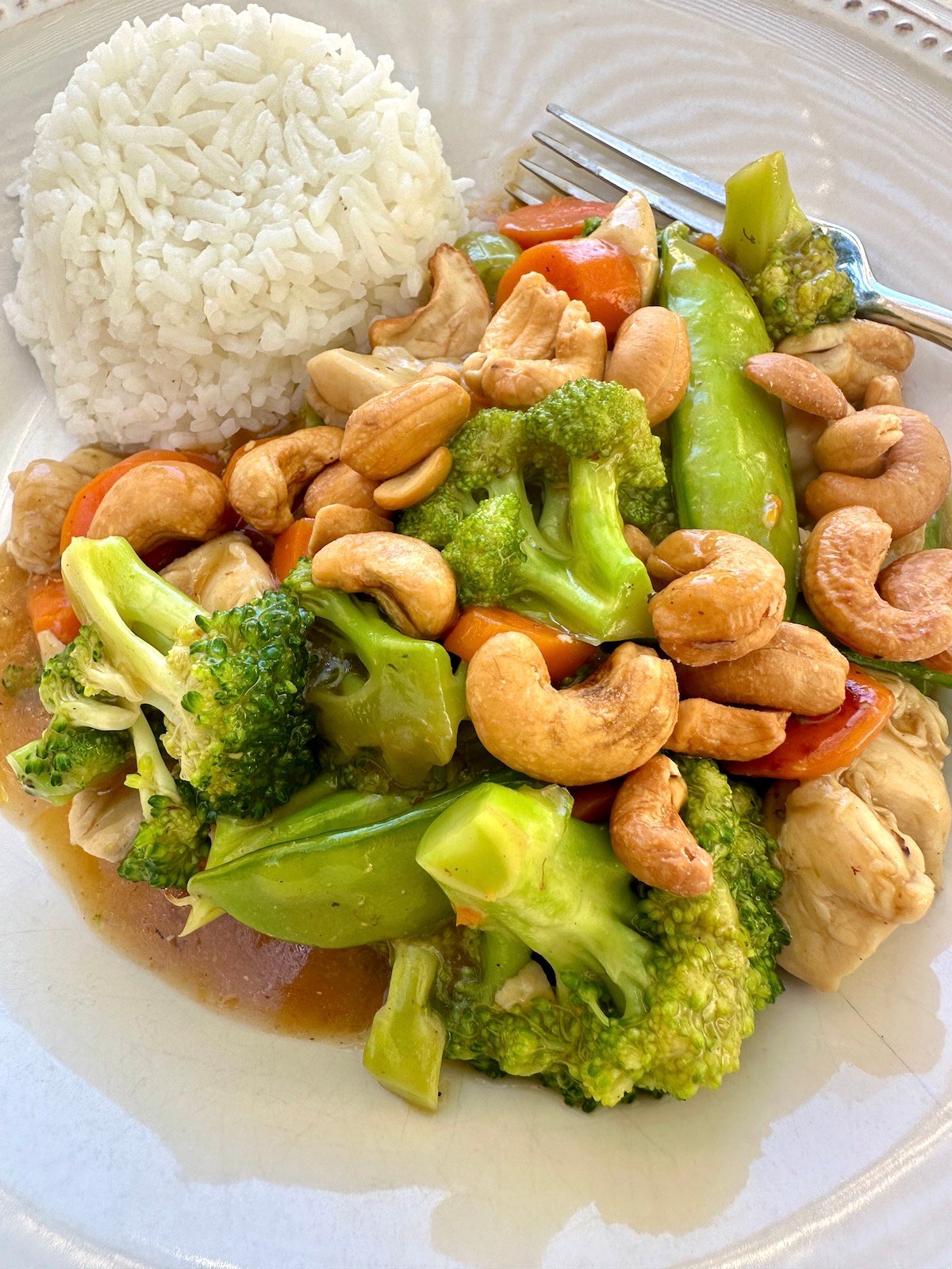 A serving of cashew chicken stir fry with rice.