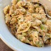 A bowl of pasta salad with a spoon.