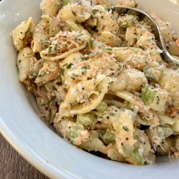 A bowl of pasta salad with a spoon.