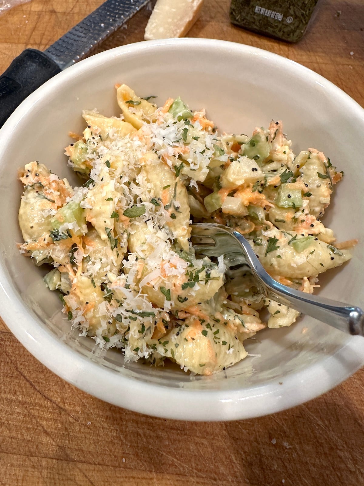 Pasta salad with salad dressing in a bowl with a fork.