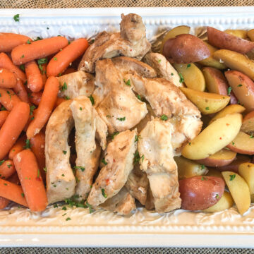 Carrots, Dutch oven chicken and potatoes on a serving dish.
