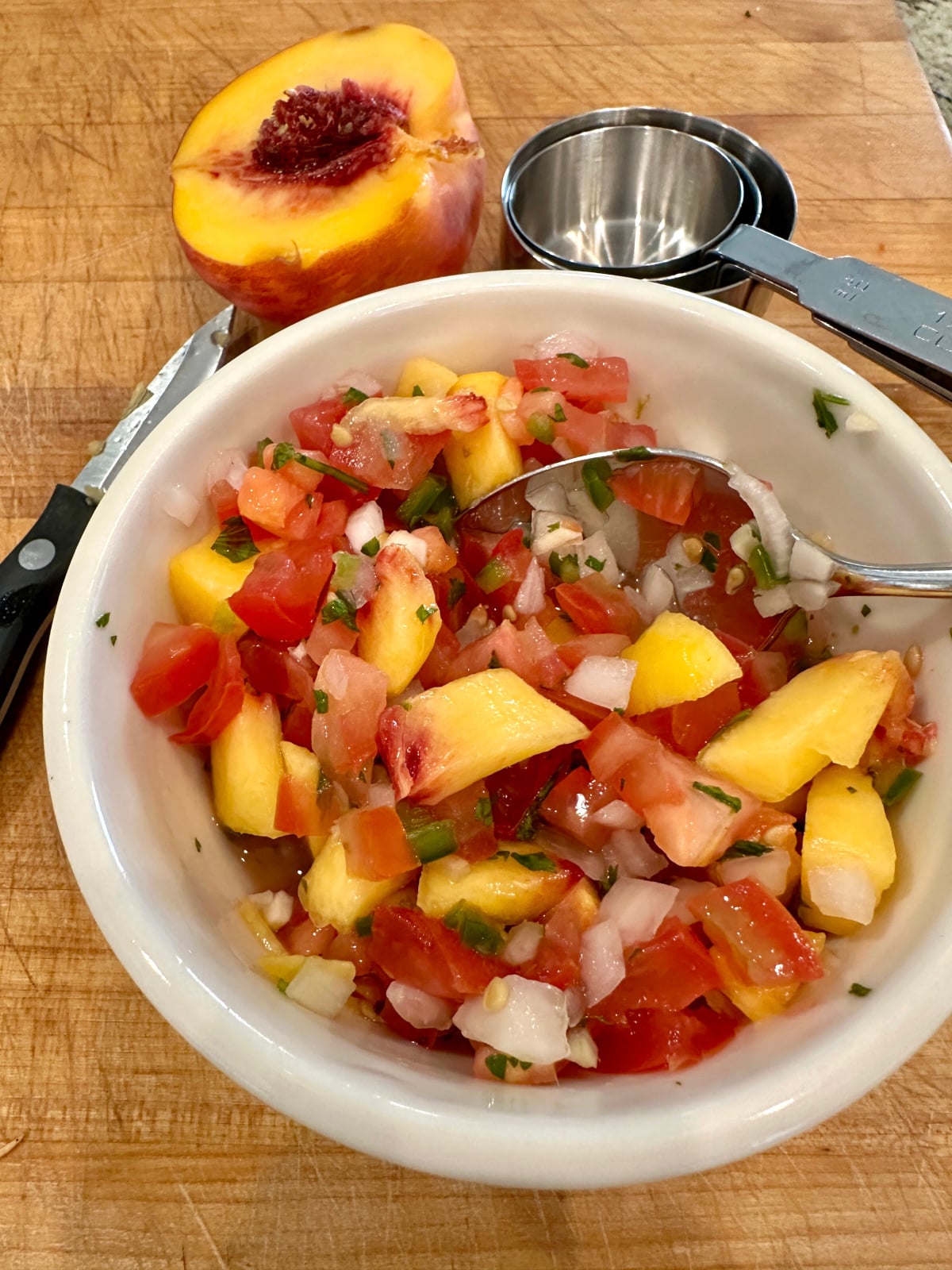 A bowl of pico de gallo with fresh peaches.