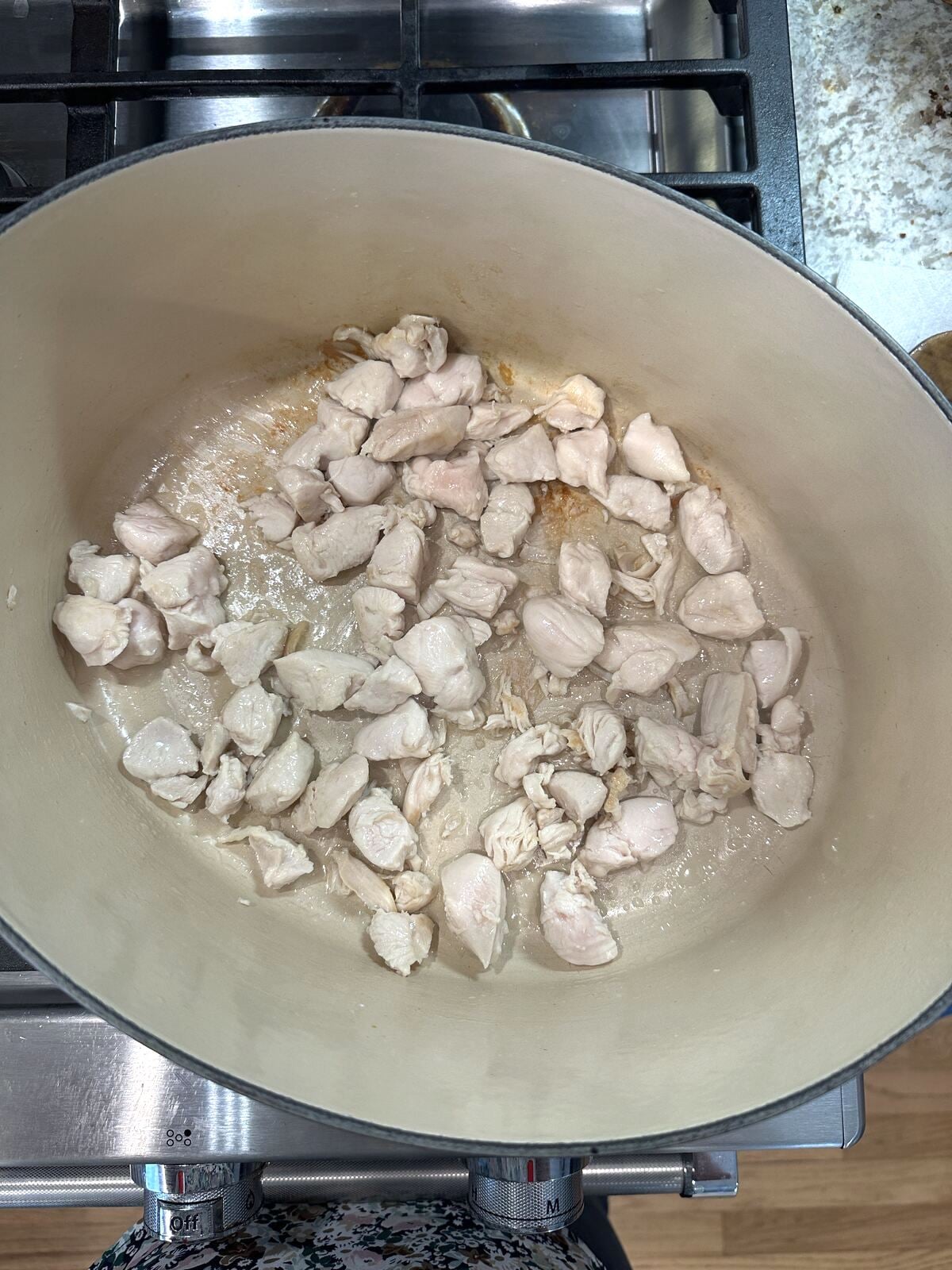 Chicken for corn soup in a Dutch oven on the stove.