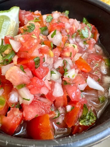 Homemade pico de gallo in a bowl with lime.