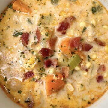 A bowl of corn and potato soup with chicken.