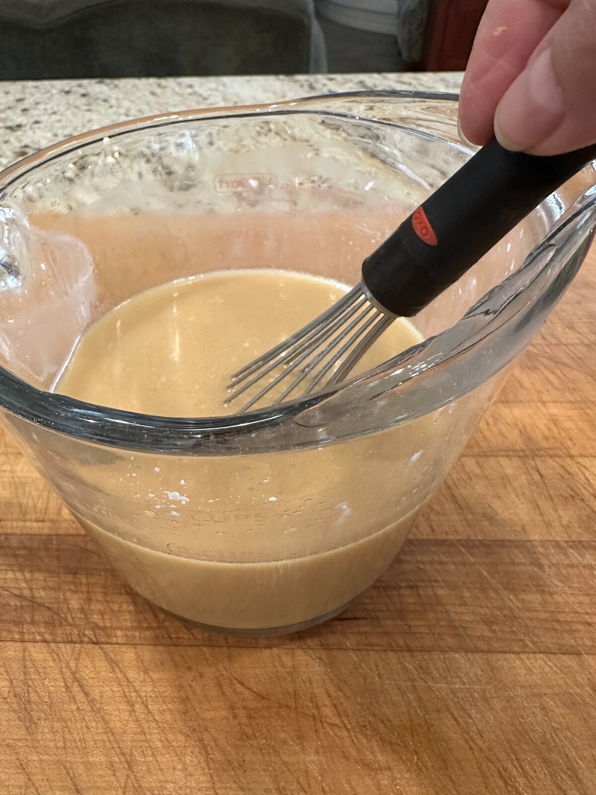 Sauce for cashew chicken stir fry in a measuring cup.